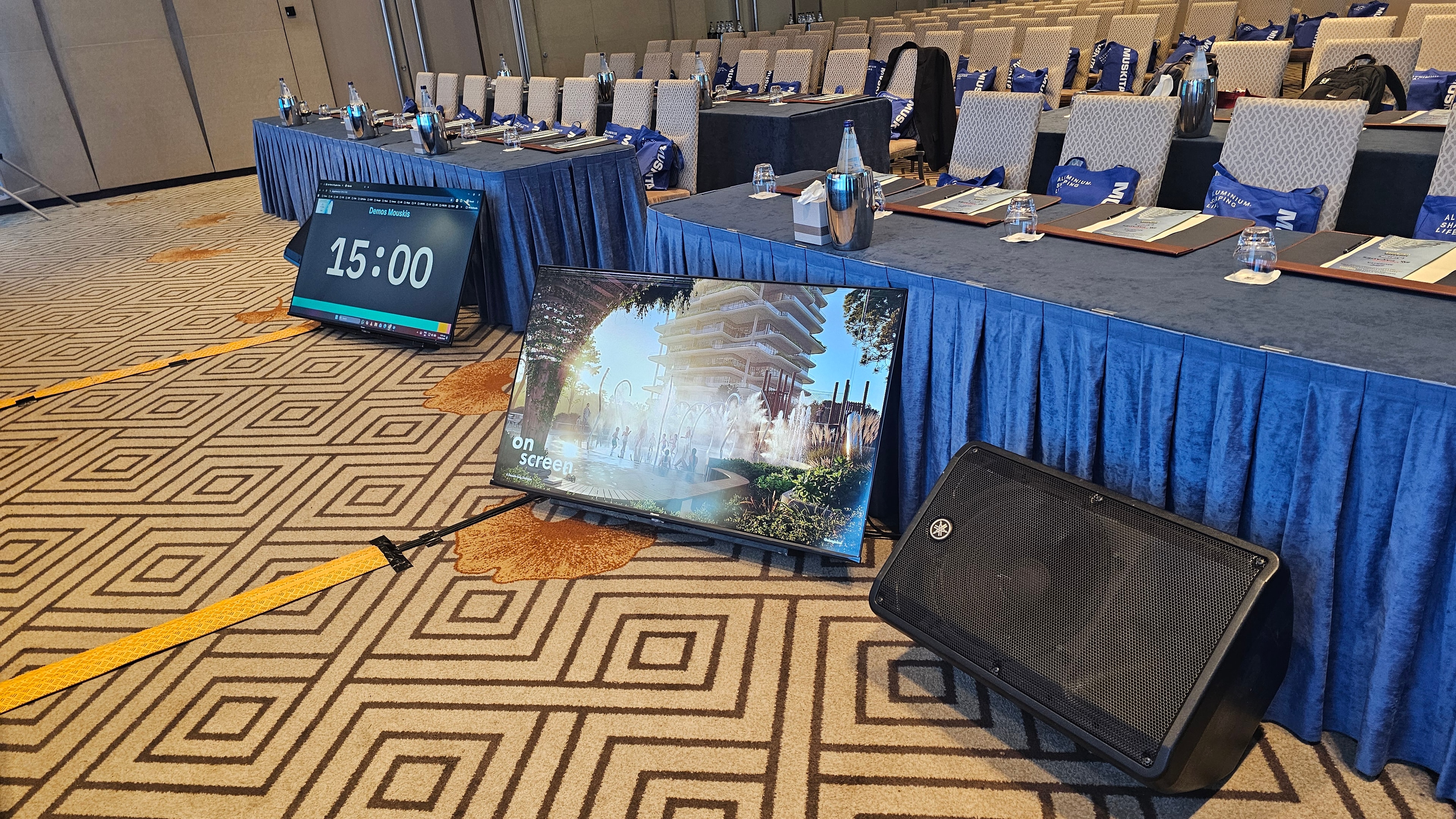 Conference room with presentation screens and a speaker at World of Façades