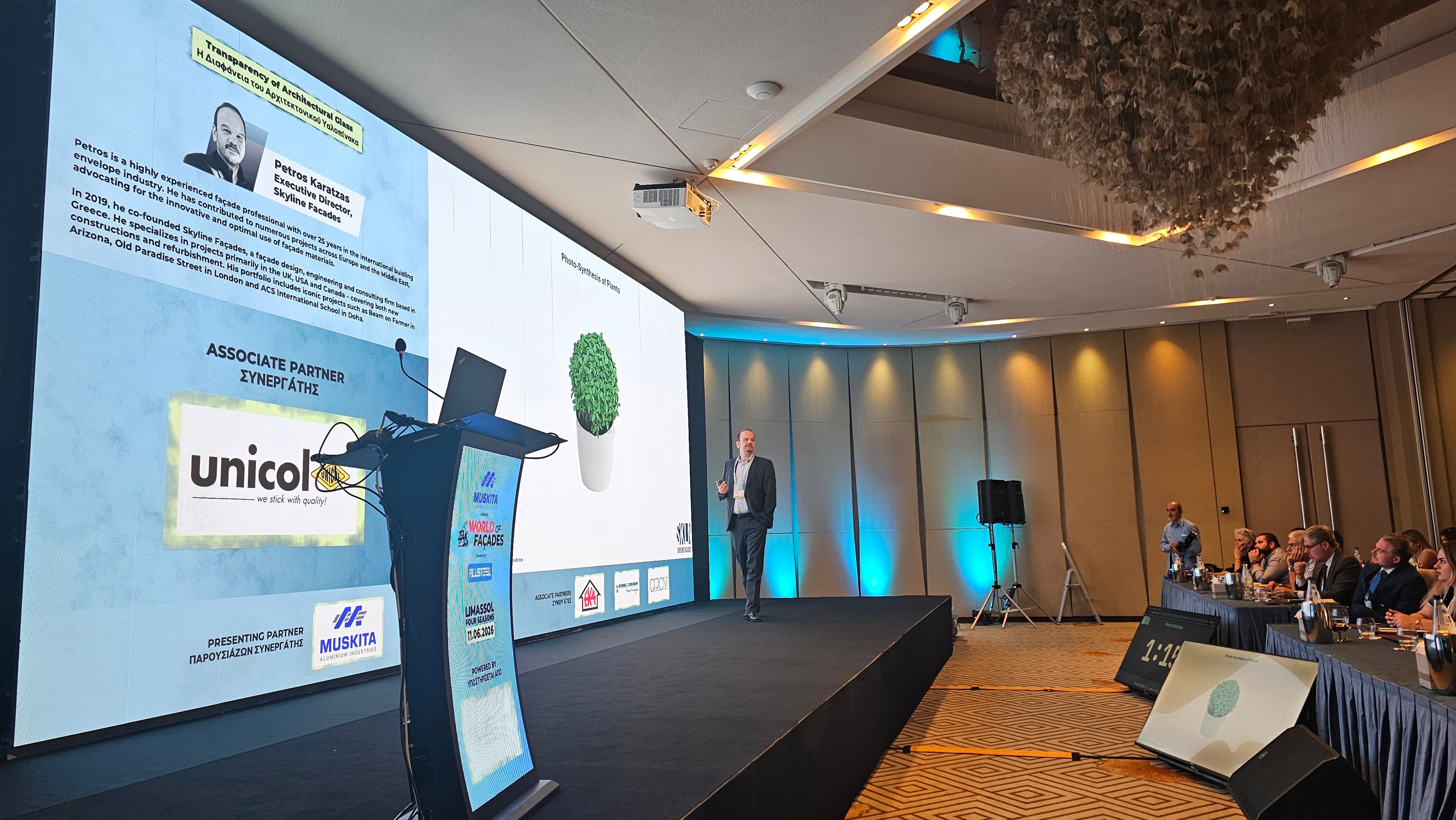 Speaker presenting at World of Façades with a floor-mounted timer in view